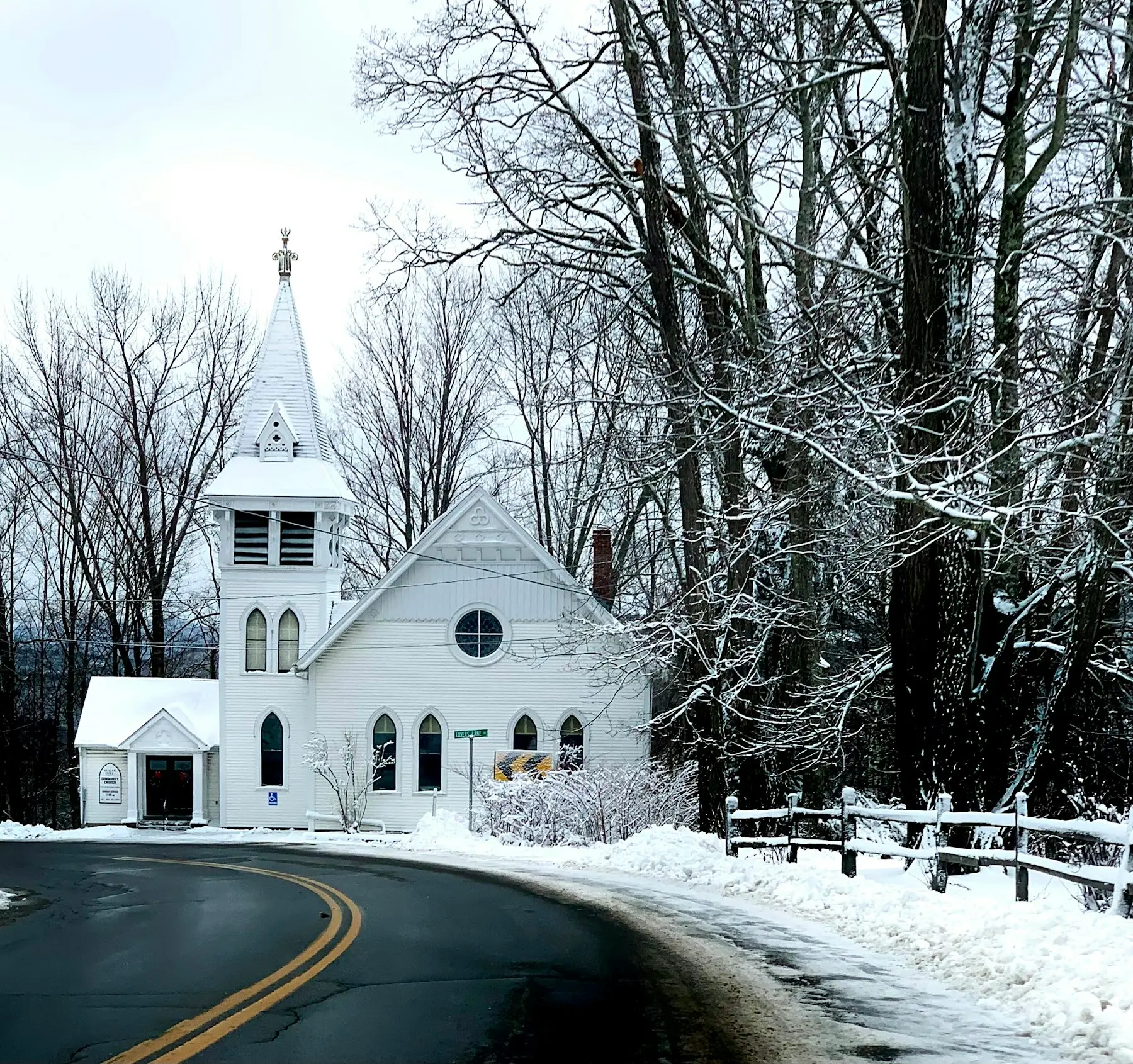 White steepled church on a snowy New England road