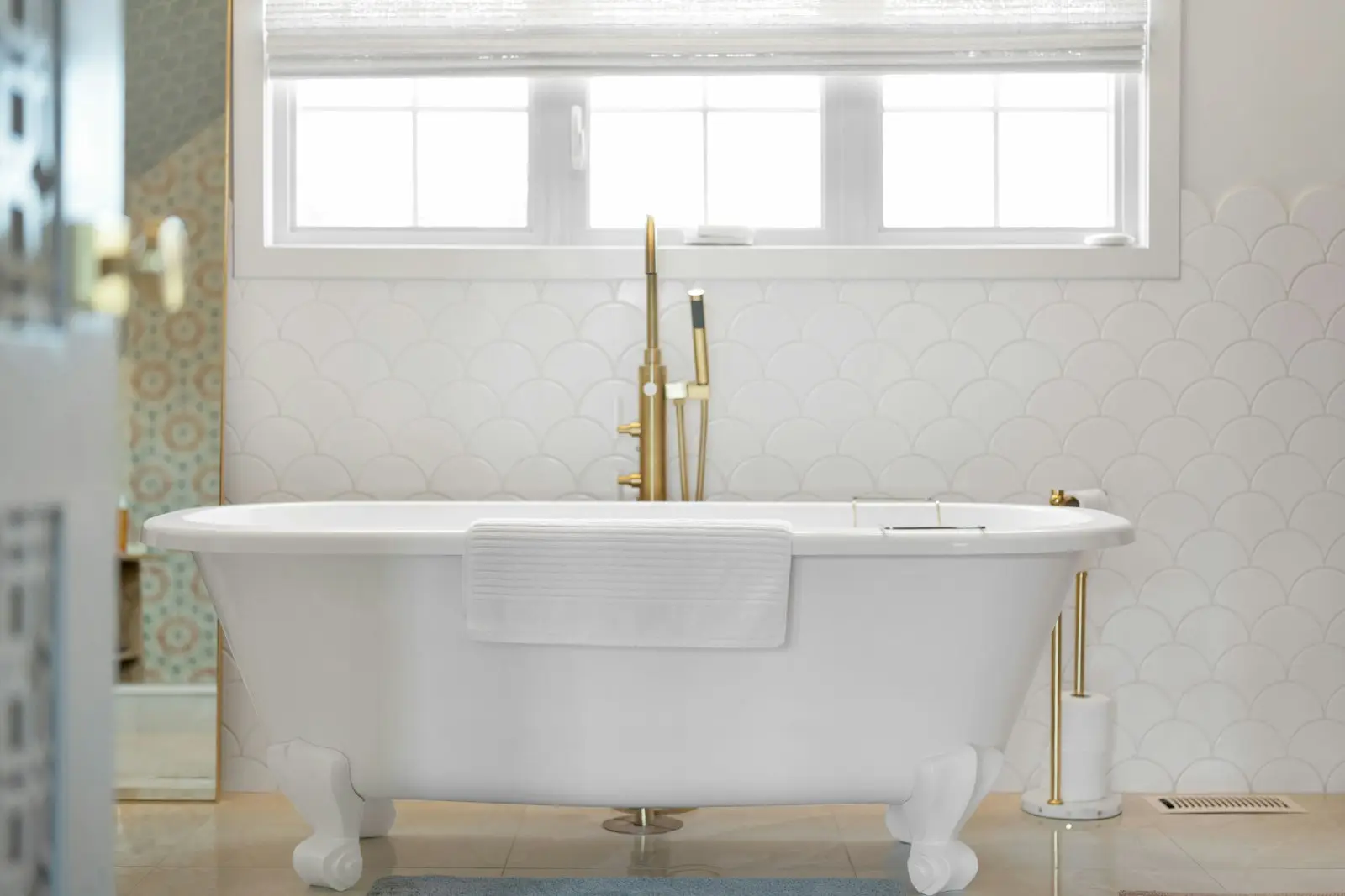 Renovated bathroom with a clawfoot tub and brass fixtures